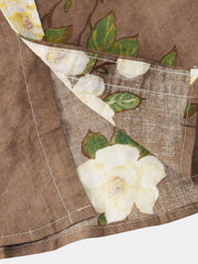 Close-up of cream flower and green leaves on taupe fabric