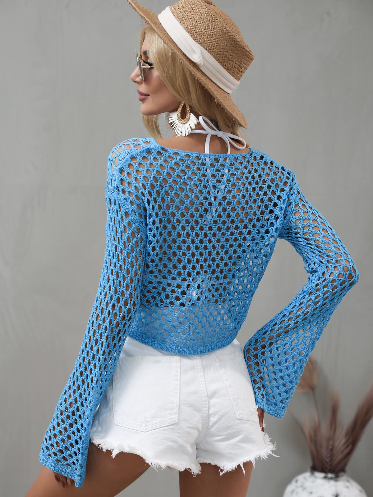 Sage green openwork cover-up modeled with its cropped hem and flared sleeves visible.