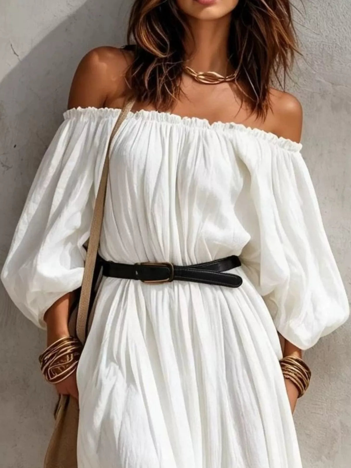Close view of white off-shoulder maxi dress with black belt and gathered bodice