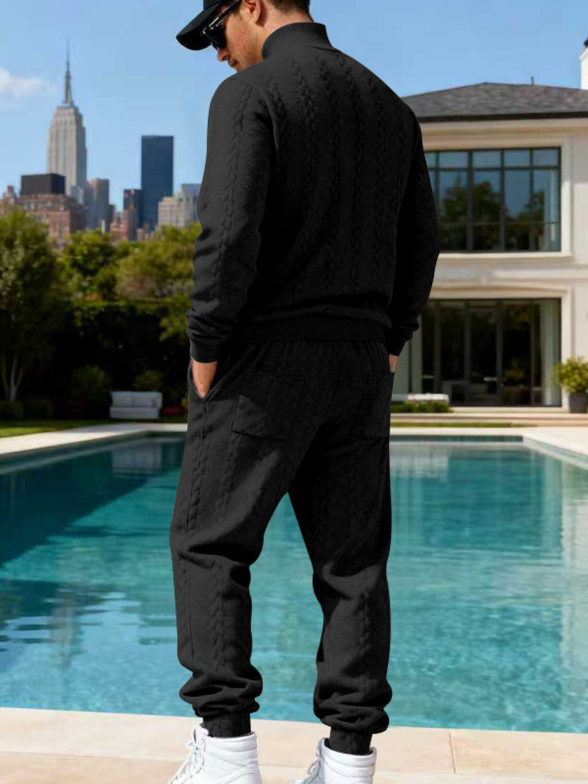 Black cable-knit sweater and joggers shown from the back.