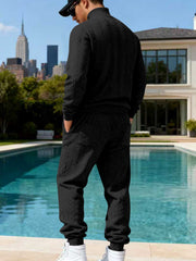 Black cable-knit sweater and joggers shown from the back.