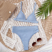 Light blue ribbed bikini set arranged flat with straps and high-waisted bottoms