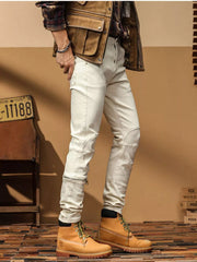 Angled front view of off-white slim-fit jeans showing shaped knee stitching