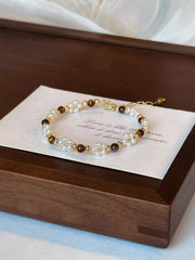 Tiger eye and pearl bracelet arranged on a card