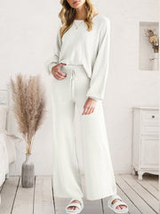 Full-length view of white V-neck lounge top and matching wide-leg pants