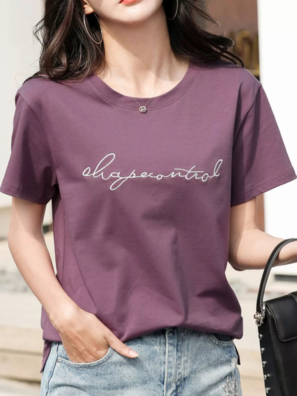 Model wearing the purple embroidered script tee, front view