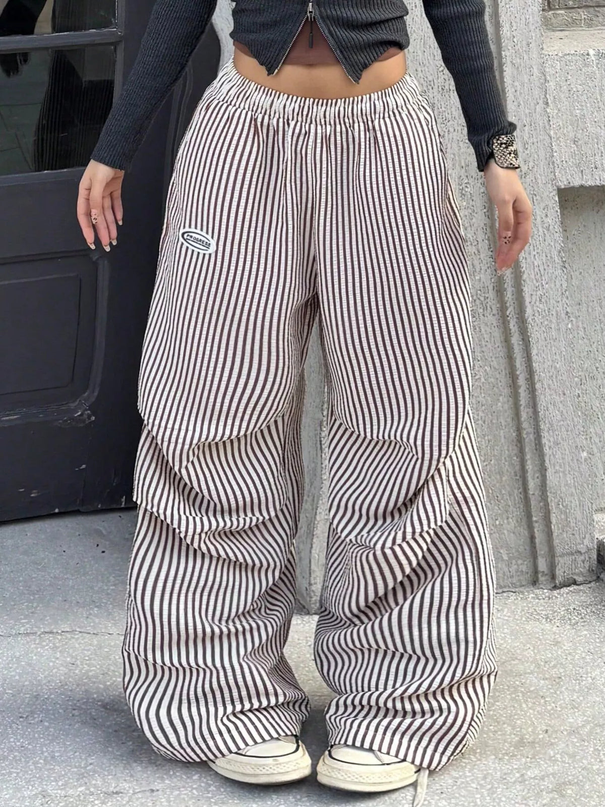 Front view of striped wide-leg pants worn with sneakers