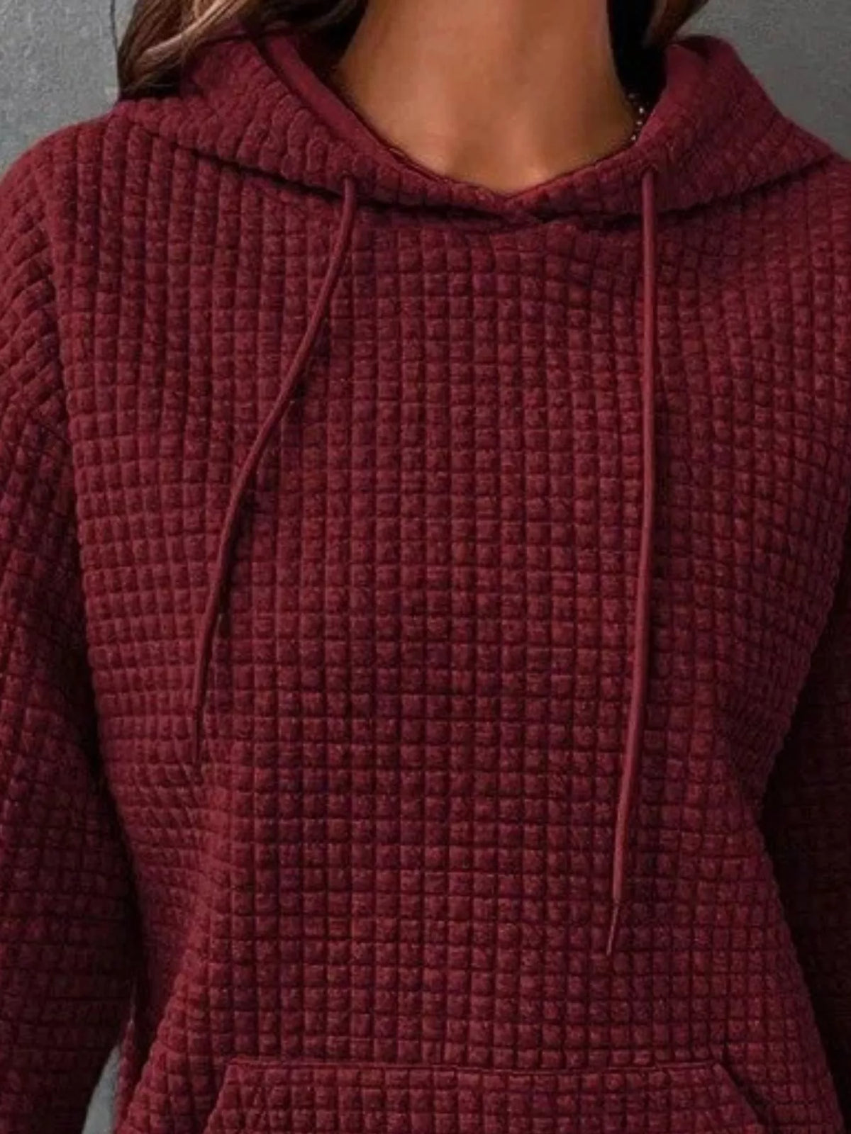 Close-up of burgundy hoodie fabric and drawstring hood