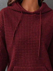 Close-up of burgundy hoodie fabric and drawstring hood