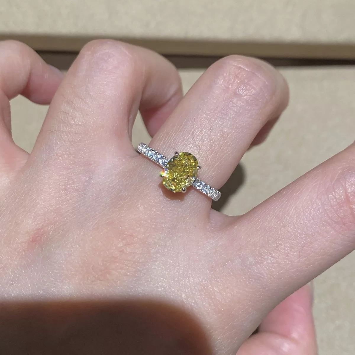 Copper-tone ring with an oval yellow center stone worn on a hand