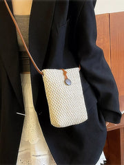 Off-white woven mini crossbody bag worn with its brown shoulder strap