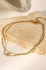 Gold-plated double-layer bracelet displayed on a light surface