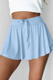 Front view of light blue skort with wide gathered waistband and tie.