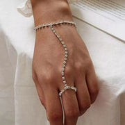 Silver-tone rhinestone hand chain bracelet worn with finger ring