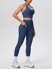 Model wearing blue halter top and leggings with hand in pocket