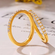 Pair of gold-tone rings showing clear zircon stones along the bands
