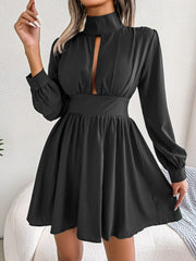 Model turns in the black cutout turtleneck mini dress