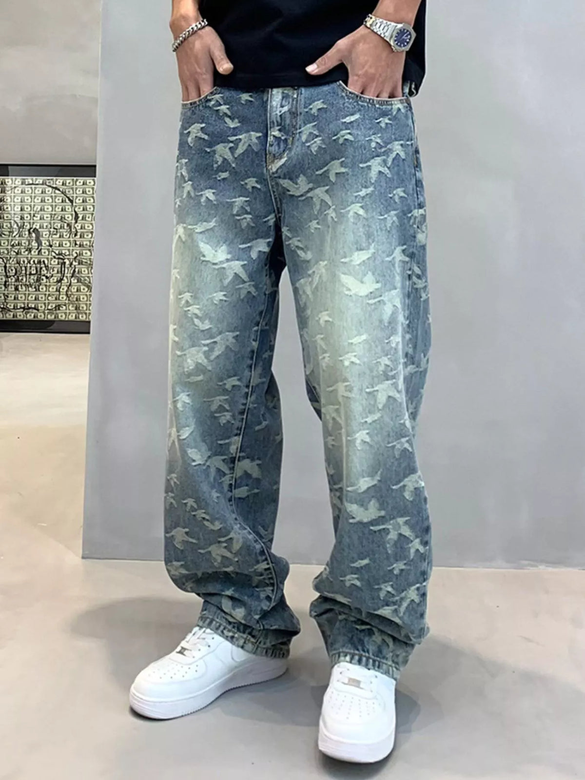 Blue bird-print jeans styled with a black top and white trainers
