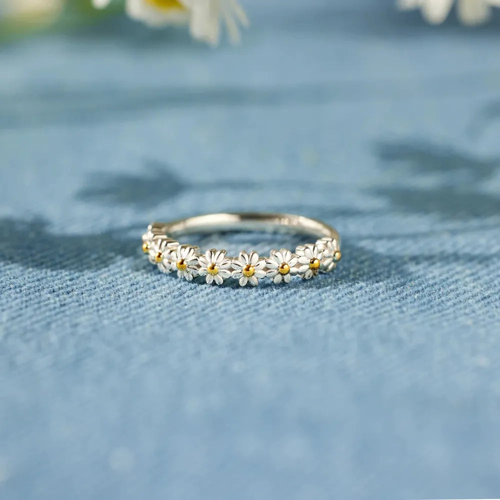 Daisy flower band ring displayed on blue fabric