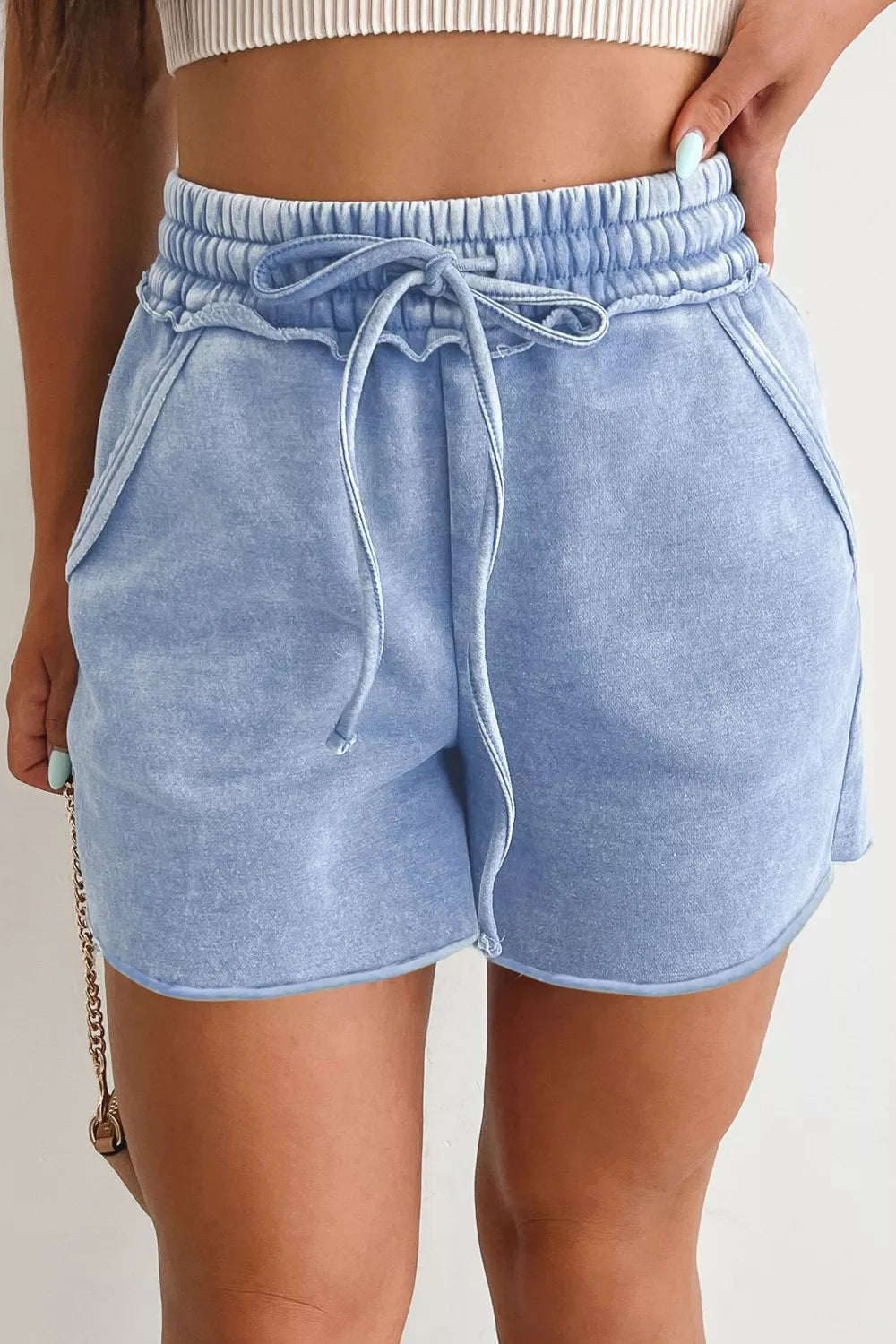 Model wearing light-blue drawstring shorts, front view