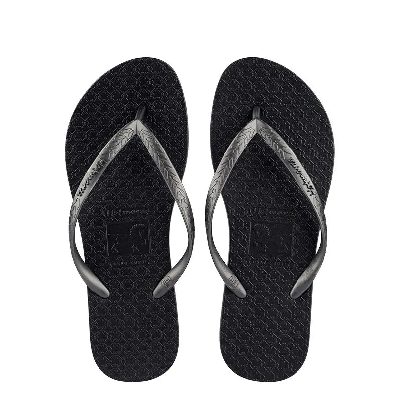 Pair of black flip-flops with silver-coloured toe-post straps, top view