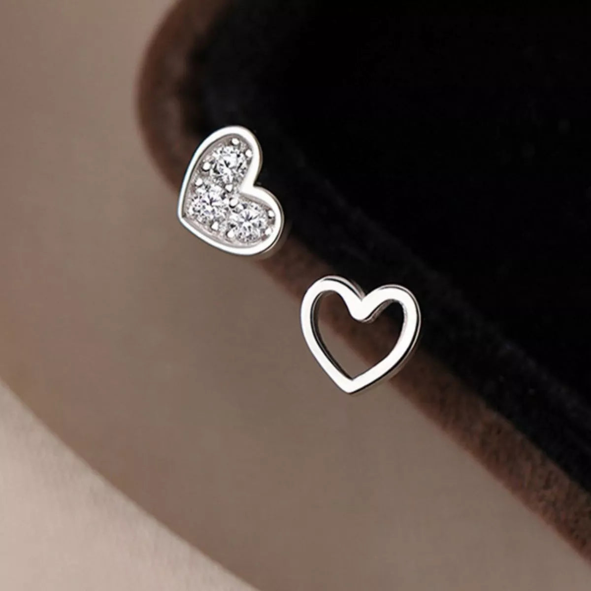Close-up of pavé heart and open heart sterling silver studs