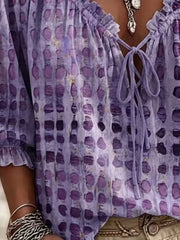 Close-up of purple blouse front showing ruffles, tie and spotted pattern
