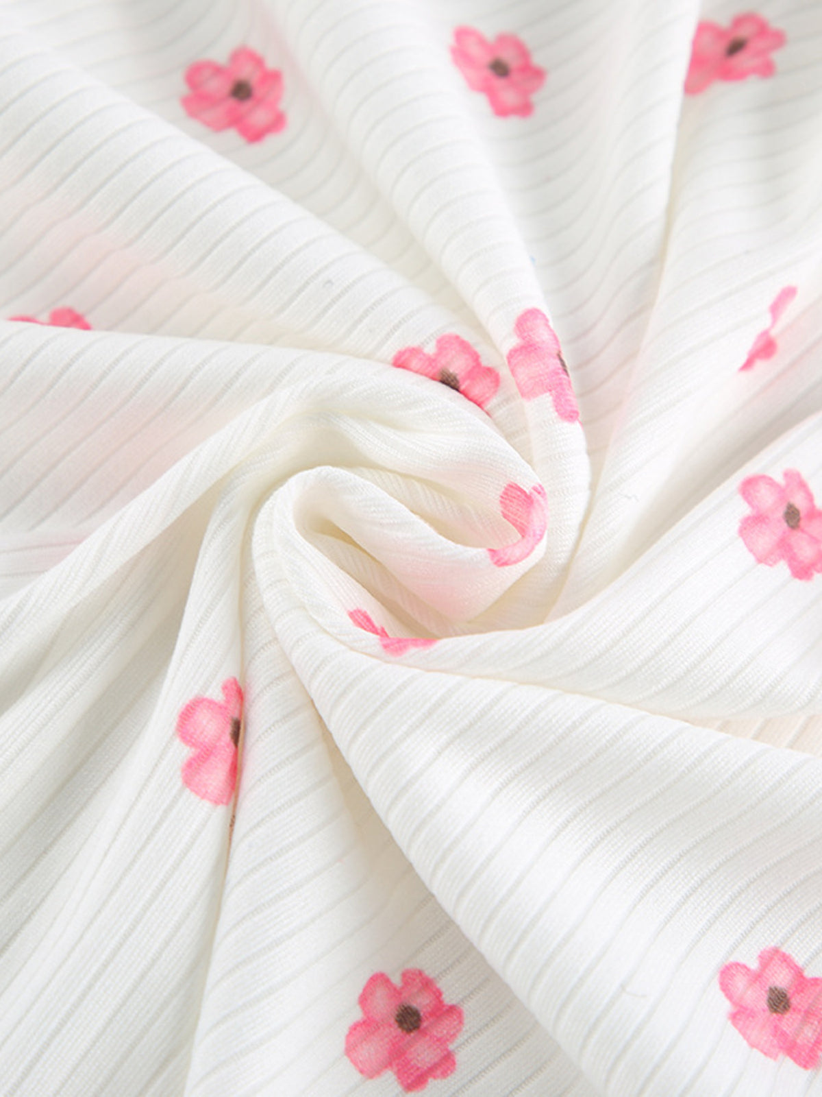 Close-up of soft white ribbed fabric with pink floral print