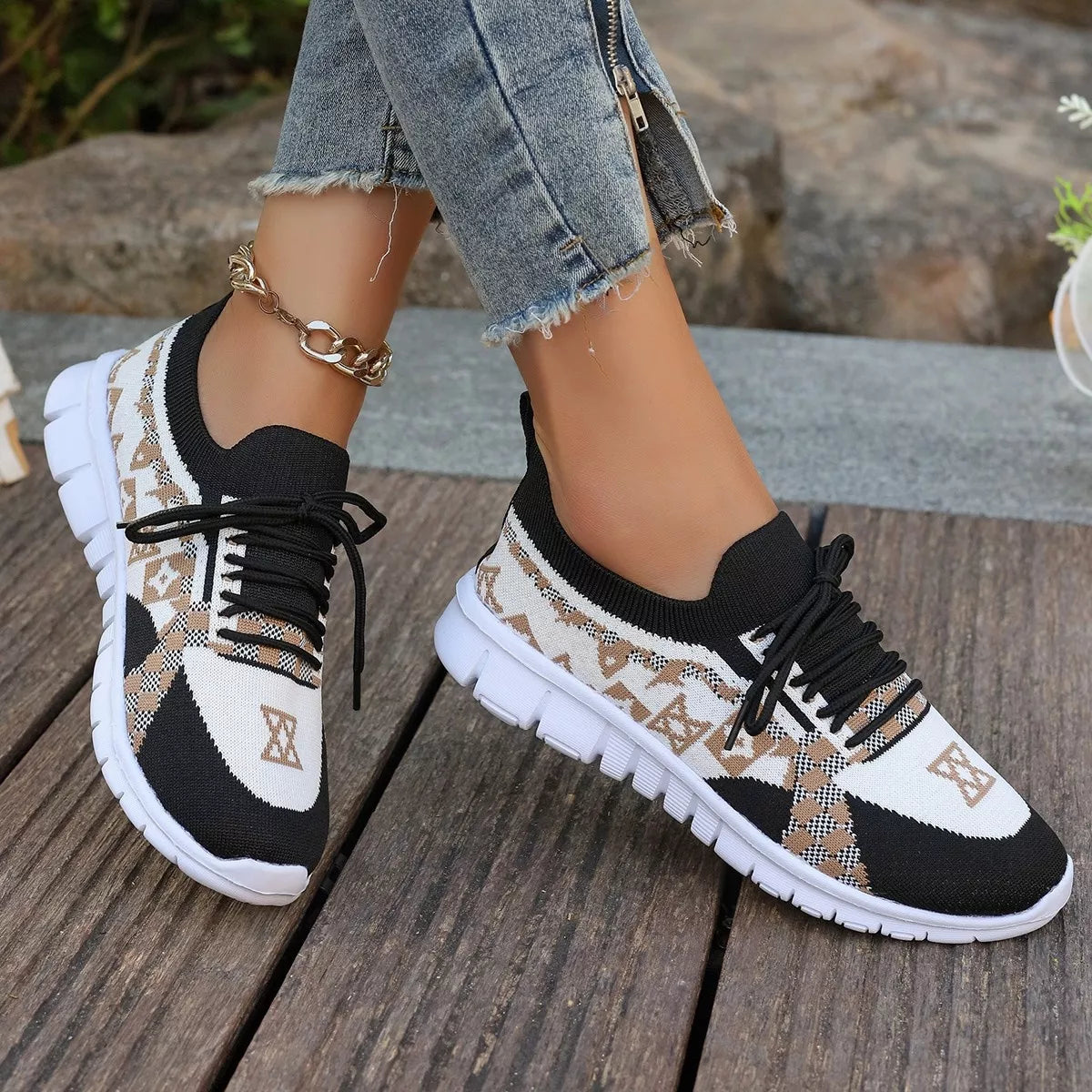 Black and white mesh lace-up sneaker with tan geometric panels, worn outdoors