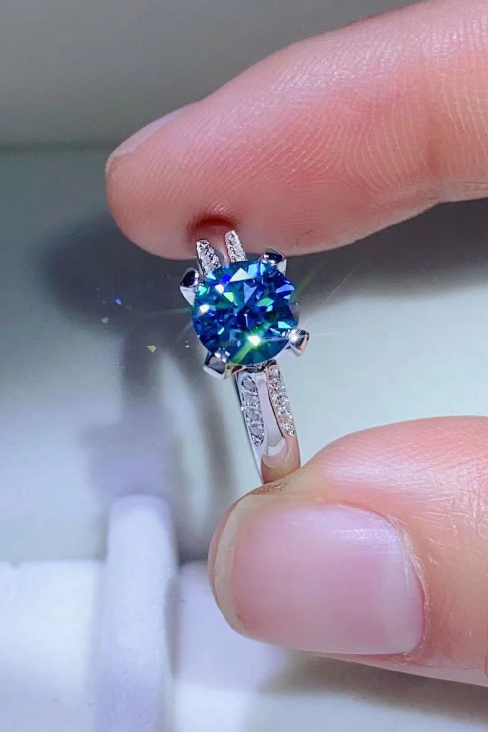 Close-up of sky-blue center stone in a four-prong ring setting