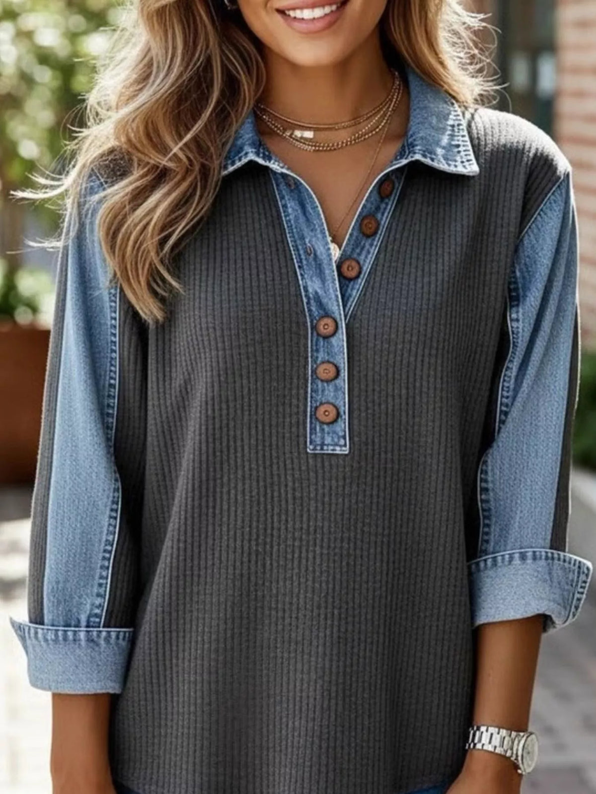 Close view of denim collar and buttons on black sweatshirt