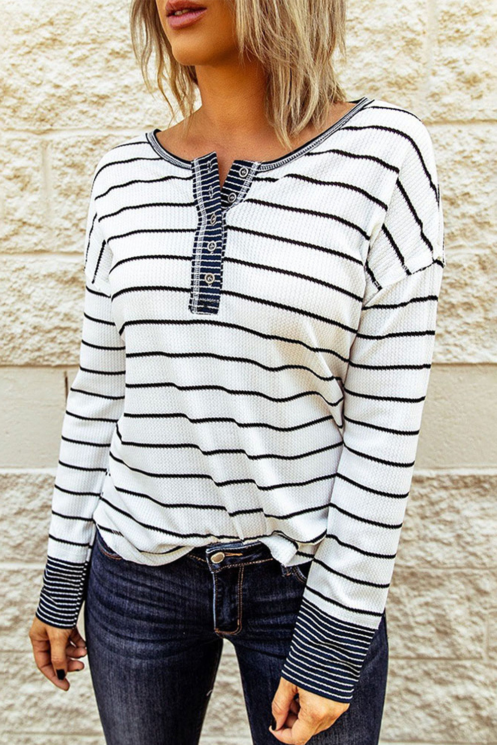 Model wearing white and black striped waffle-knit Henley with button placket