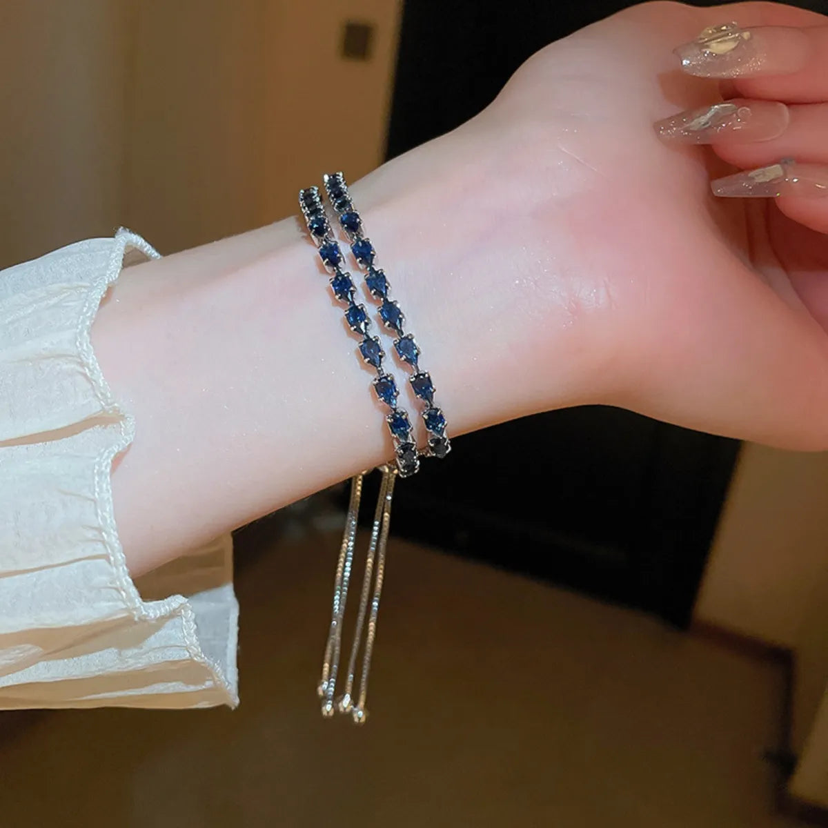 Wrist view of the blue-stone bracelet with its dangling adjustable chain