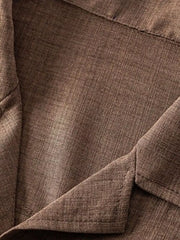 Close-up of the brown shirt fabric and chest pocket.