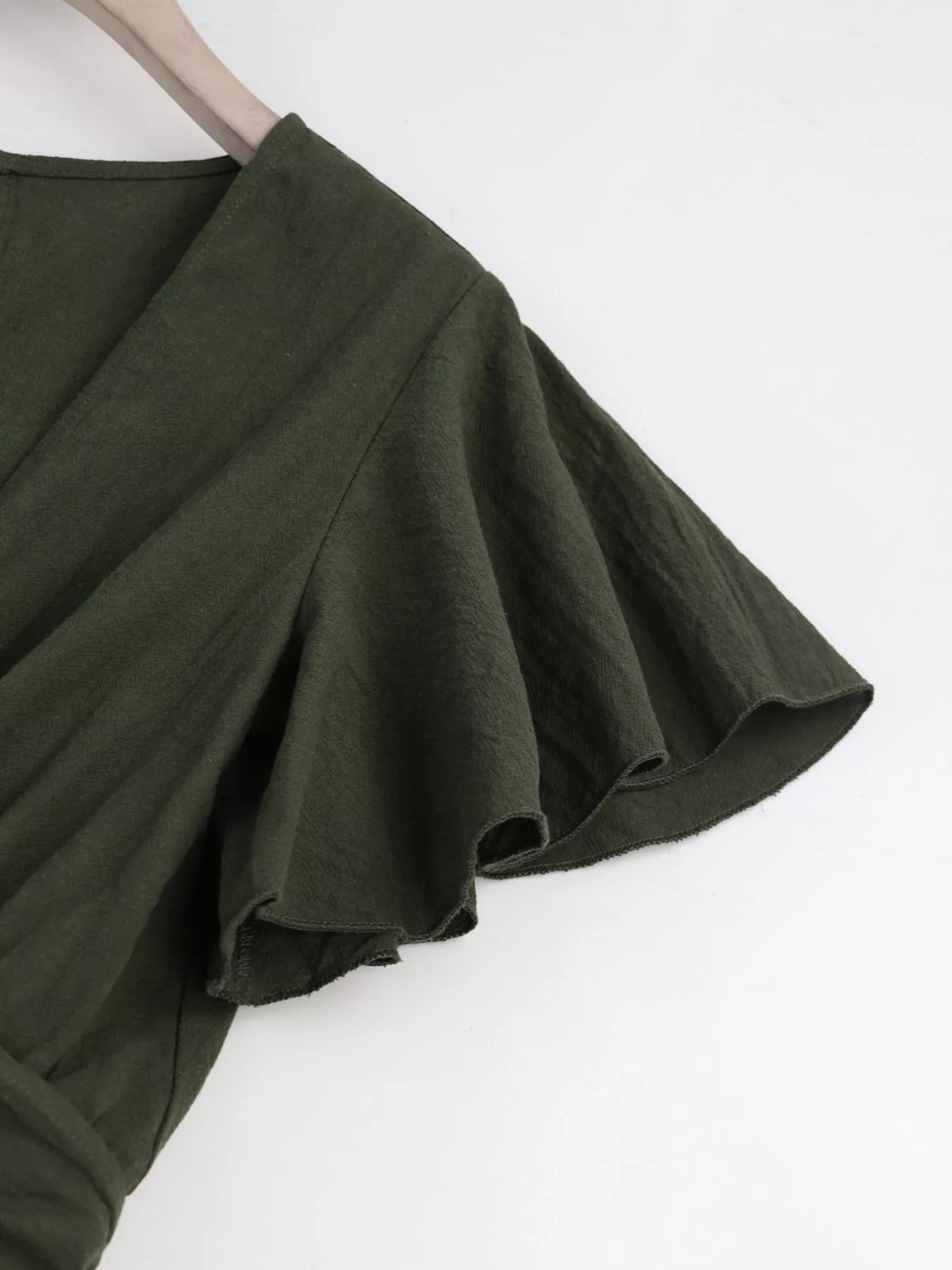 Close-up of olive flutter sleeve