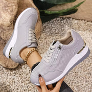 Gray knit sneaker side view showing white sole and heel detail
