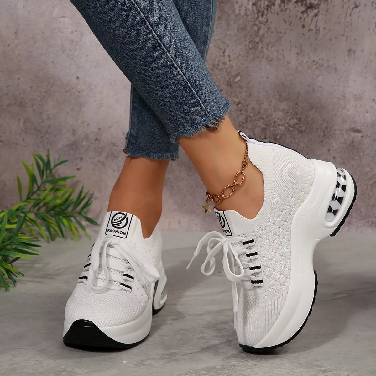 White lace-up platform sneakers worn with blue jeans, front angled view