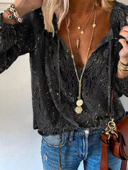 Black lace blouse styled with blue jeans, front view of tied neckline