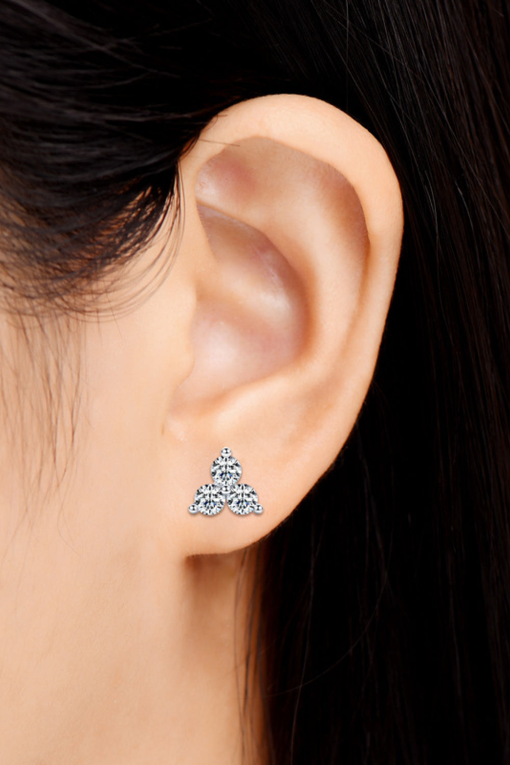 Three-stone moissanite stud earring worn on ear