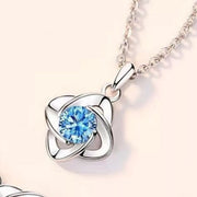 Silver-tone clover pendant with bright blue center stone shown close-up