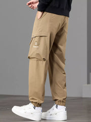 Angled side view of tan cargo joggers with flap pocket and gathered ankle cuffs.