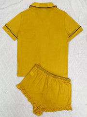 Back view of mustard lounge shirt and ruffle-hem shorts with black piping