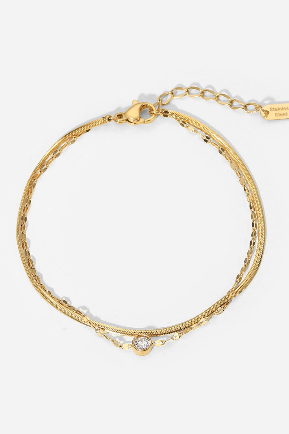Gold-tone double-layer bracelet with a round clear rhinestone