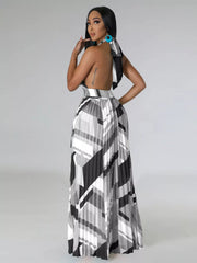 Three-quarter back view of a black-and-white halter maxi dress showing the open back.