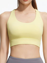 Close front view of pale yellow active bra showing the scoop neckline and curved underbust seam