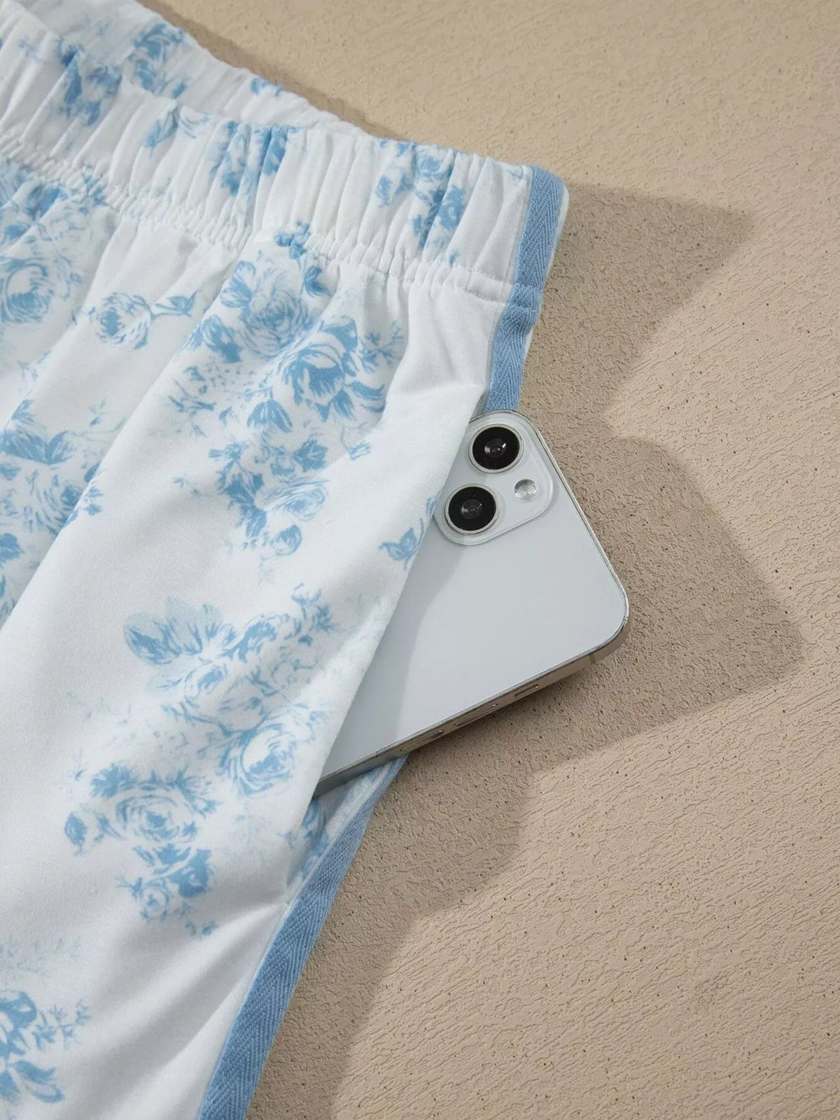 Close-up of elastic waistband and blue side stripe on floral shorts