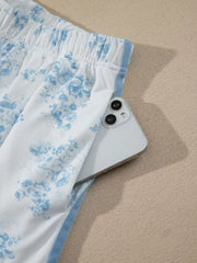 Close-up of elastic waistband and blue side stripe on floral shorts