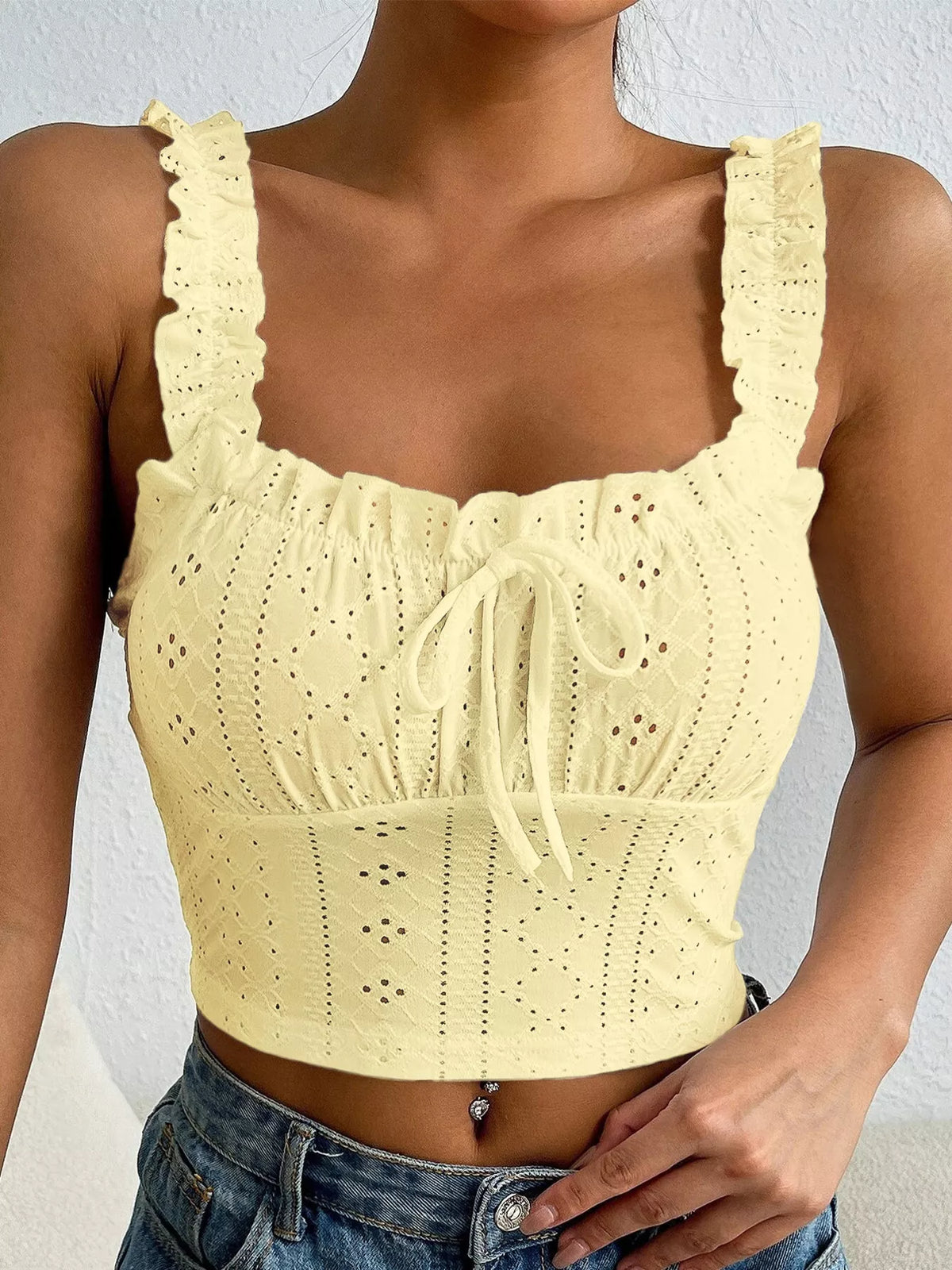 Close view of pale yellow eyelet stitching and tie-front neckline