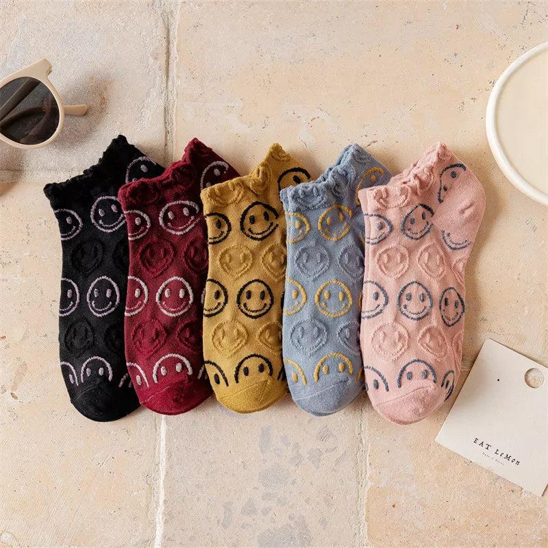 Five smiley-face ankle socks in black, burgundy, mustard, blue and pink