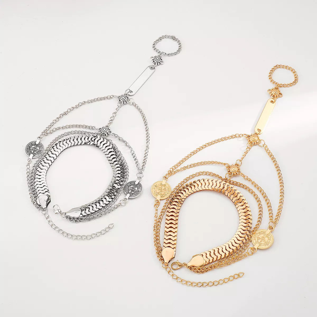 Gold and silver-tone layered chain hand bracelets displayed together